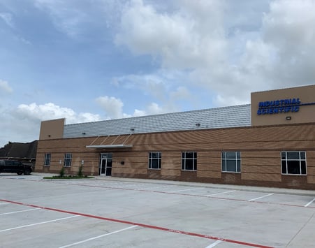 Industrial Scientific's Houston location building sits beneath a blue sky and fluffy clouds