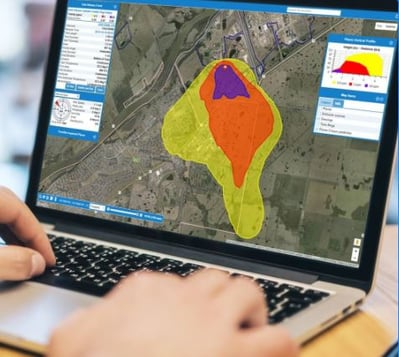 a laptop screen shows a dynamic plume model of a chemical leak overlaid on a map