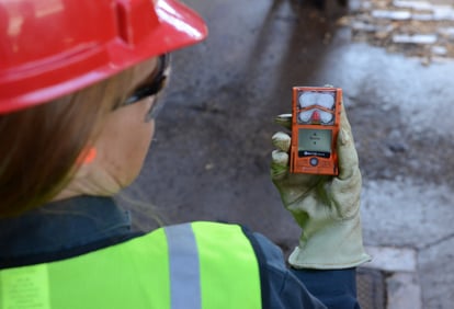 industrial worker looking down at personal gas detector screen