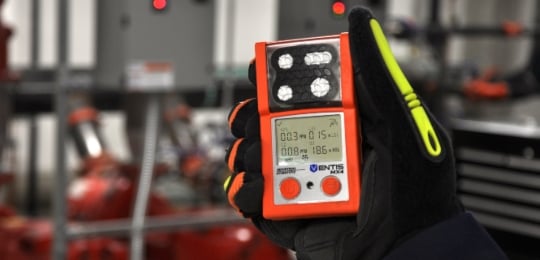 Close shot of gloved hand holding a Ventis MX4 personal gas monitor