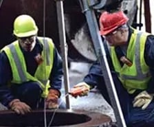 picture of two workers using confined space monitors to test a confined space