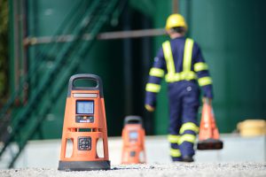 worker walking away from camera places area gas monitors in a row