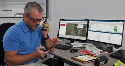 in a safety control room, a safety manager sits in front of a dashboard displaying a gas exposure alarm. They call for help