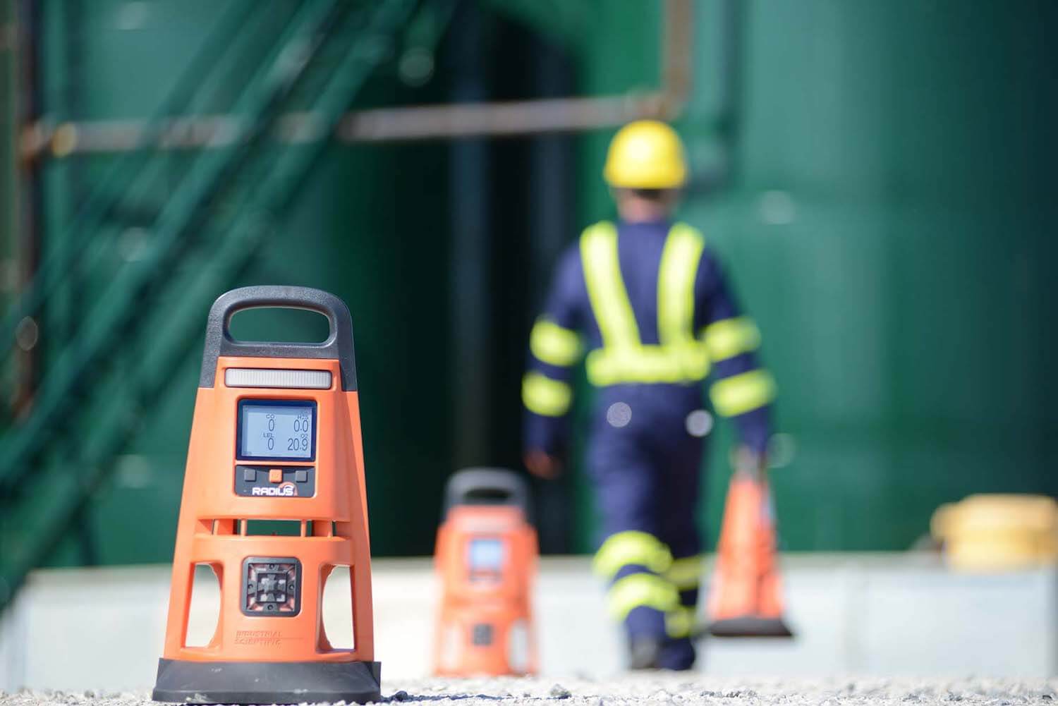 worker placing area gas monitors along the perimeter of his worksite