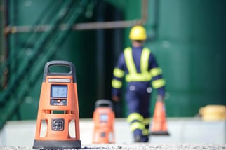 worker placing area gas monitors along the perimeter of his worksite