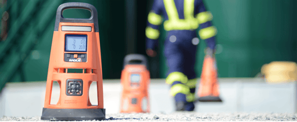 worker placing area gas monitors along the perimeter of his worksite