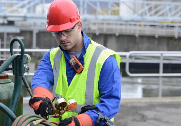 hydrogen sulfide detector (H2S monitor) clipped on the collar of an industrial worker