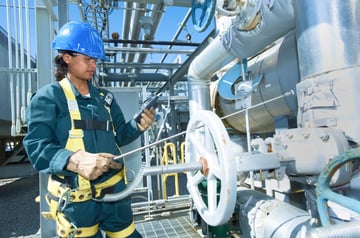 worker in chemical plant uses a sampling pump to take a gas reading