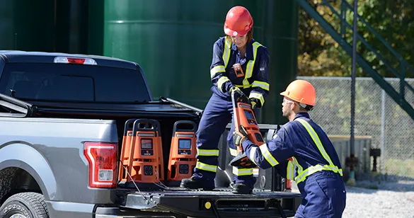 two industrial workers load area monitors for perimeter monitoring onto a truckbed